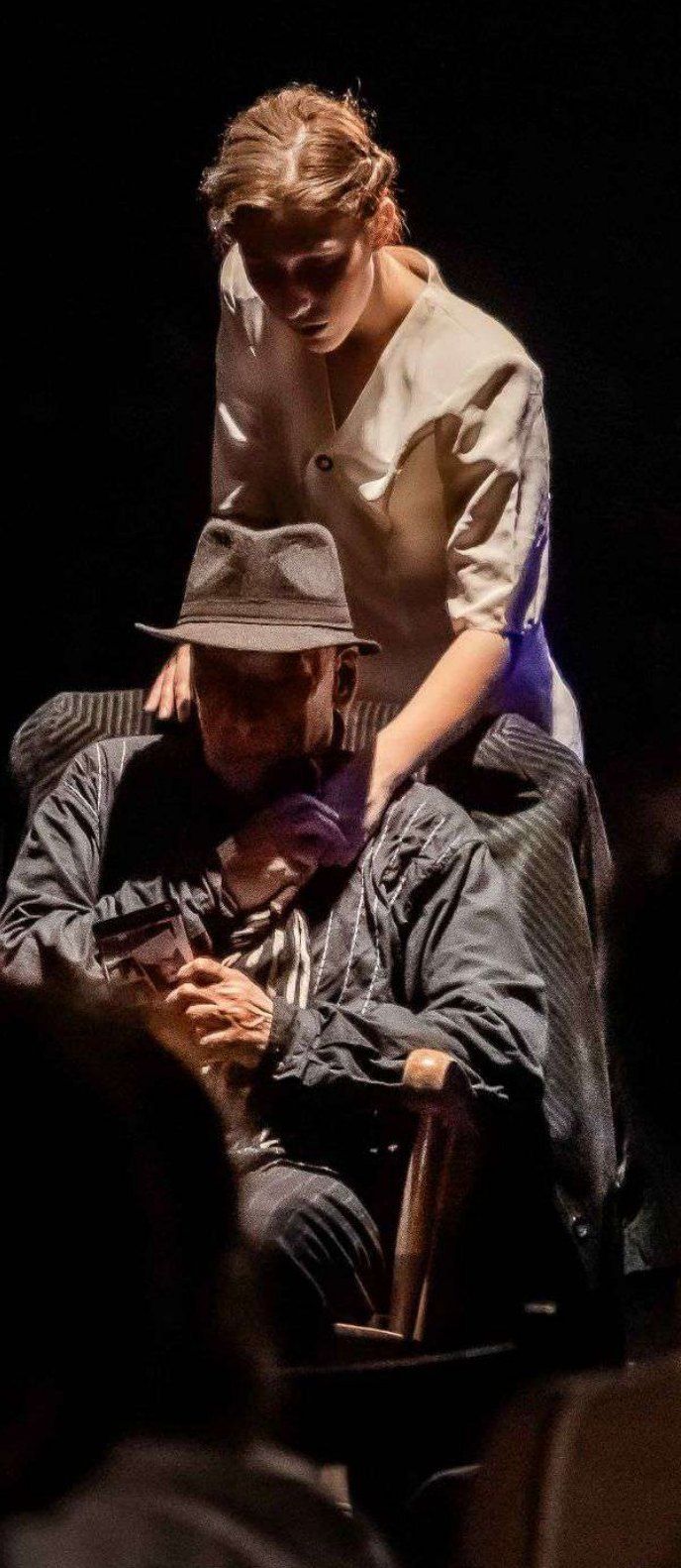Une femme penchée sur le vieil homme au chapeau