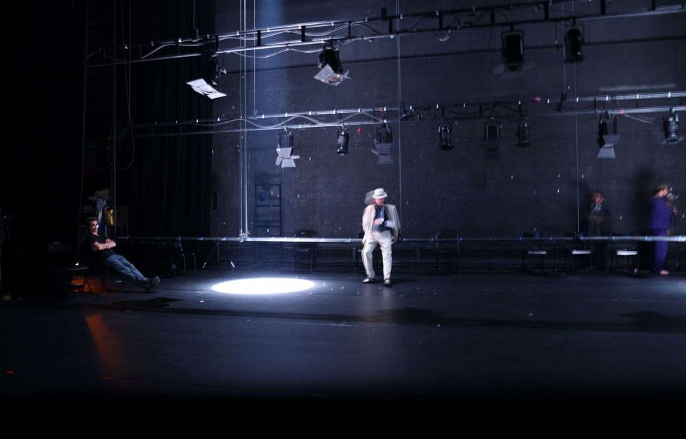 La salle, l’échafaudage mis à nu, un comédien dans le rond de lumière